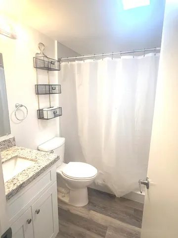 a bathroom with a granite countertop sink toilet and shower