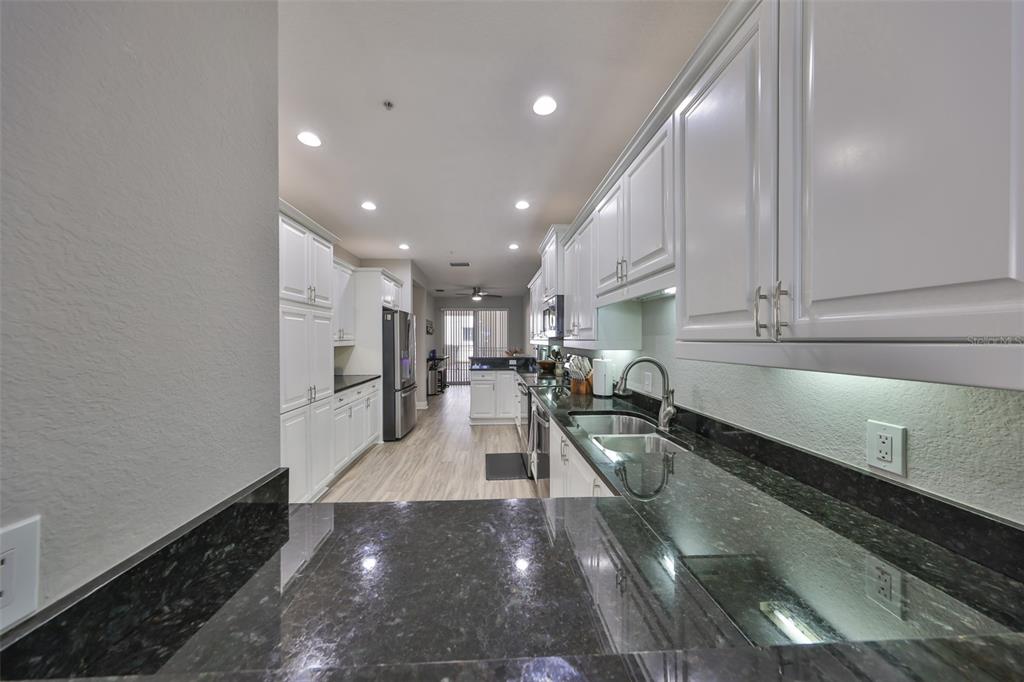 1038 Bellasol Way, Unit 202 Apollo Beach, FL 33572 - Photo 18 of 52 a kitchen with a sink stainless steel appliances and cabinets