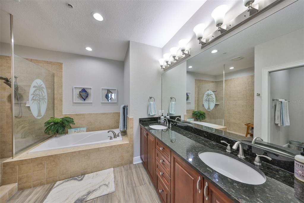 1038 Bellasol Way, Unit 202 Apollo Beach, FL 33572 - Photo 23 of 52 a spacious bathroom with a granite countertop double vanity sink a mirror and a bathtub