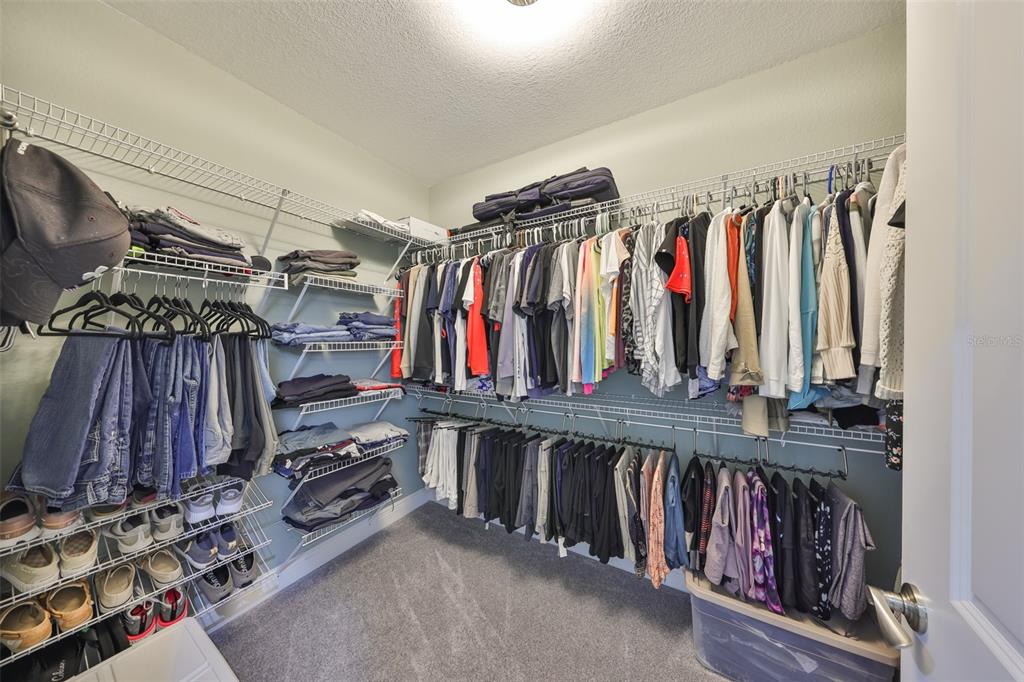 1038 Bellasol Way, Unit 202 Apollo Beach, FL 33572 - Photo 25 of 52 a view of walk in closet with clothes and shoes