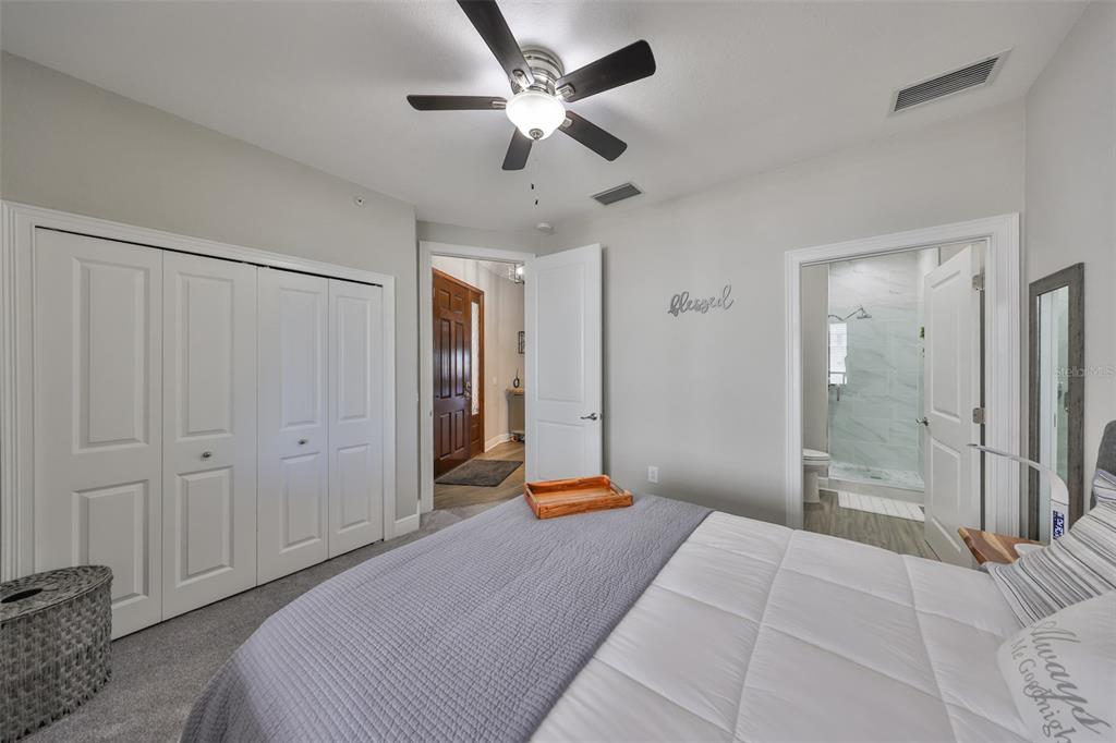 1038 Bellasol Way, Unit 202 Apollo Beach, FL 33572 - Photo 30 of 52 a bedroom with a bed and a chandelier