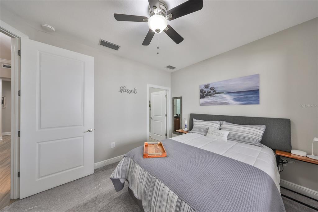 1038 Bellasol Way, Unit 202 Apollo Beach, FL 33572 - Photo 31 of 52 a bedroom with a bed and a chandelier