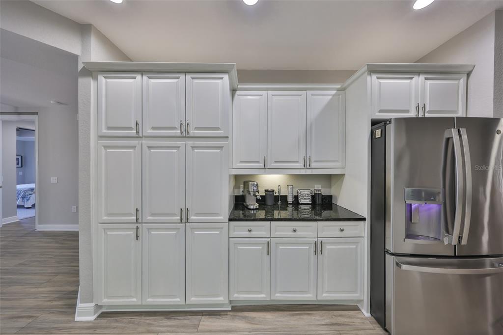 1038 Bellasol Way, Unit 202 Apollo Beach, FL 33572 - Photo 9 of 52 a kitchen with white cabinets and refrigerator