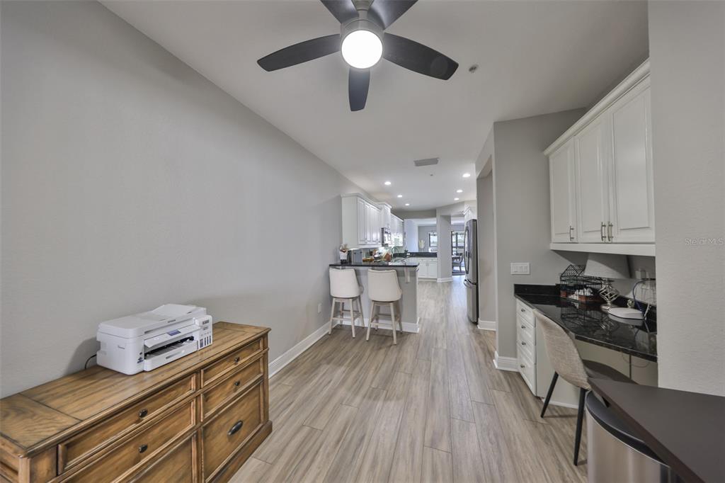 1038 Bellasol Way, Unit 202 Apollo Beach, FL 33572 - Photo 10 of 52 a kitchen with stainless steel appliances granite countertop a stove top oven a sink a dining table and chairs with wooden floor