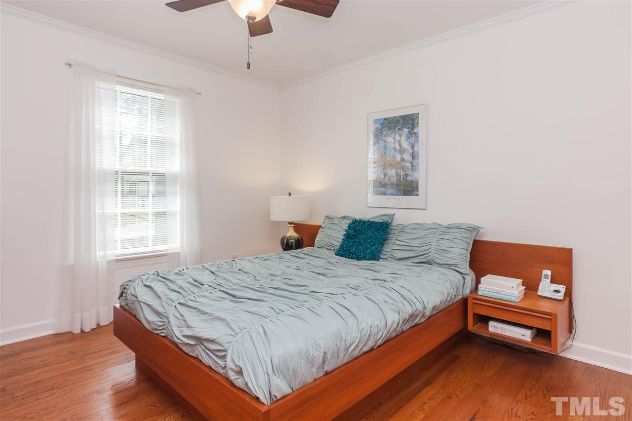 7008 Robbie Drive Raleigh, NC 27607 - Photo 14 of 21 a bedroom with a bed and wooden floor