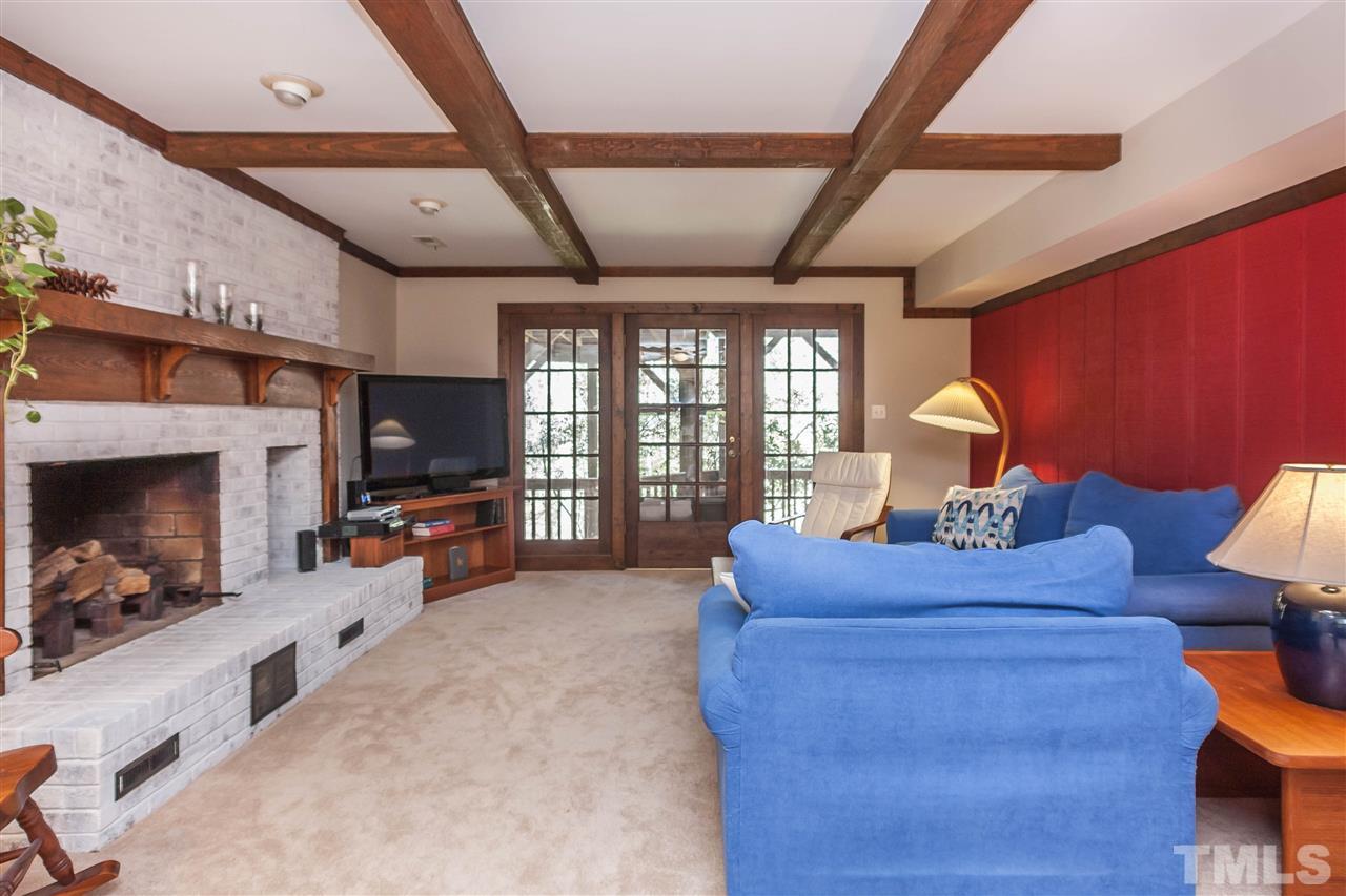 7008 Robbie Drive Raleigh, NC 27607 - Photo 15 of 21 a living room with furniture a flat screen tv and a fireplace