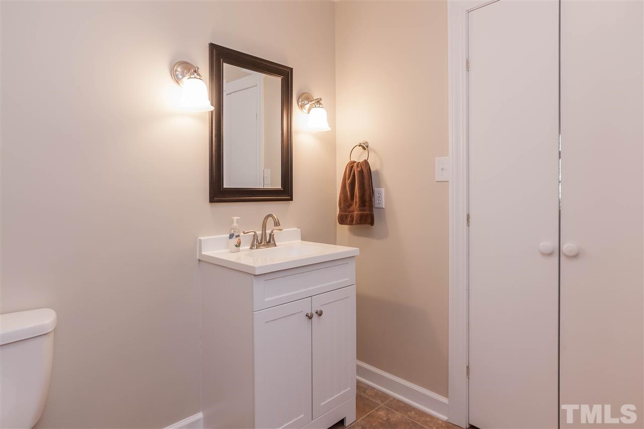 7008 Robbie Drive Raleigh, NC 27607 - Photo 17 of 21 a bathroom with a granite countertop sink and a mirror