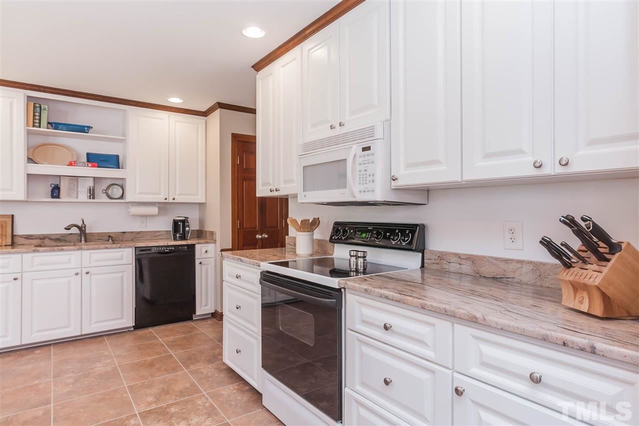 7008 Robbie Drive Raleigh, NC 27607 - Photo 7 of 21 a kitchen with granite countertop white cabinets white stainless steel appliances with a sink and dishwasher