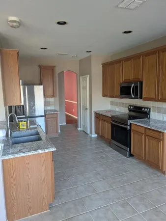 a kitchen with stainless steel appliances granite countertop a stove a sink and a refrigerator
