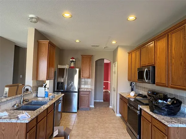 a kitchen with stainless steel appliances granite countertop a sink stove and refrigerator