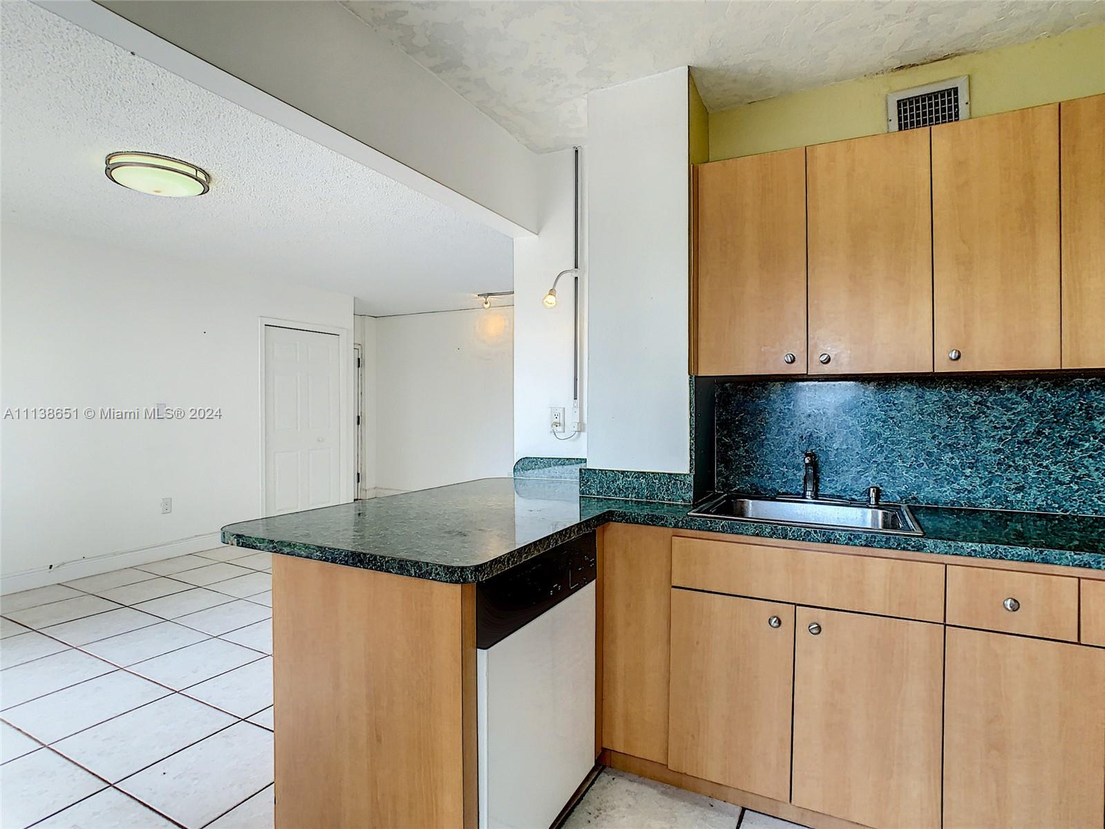 6445 Indian Creek Drive, Unit B16 Miami Beach, FL 33141 - Photo 4 of 18 a kitchen with granite countertop a sink and a stove