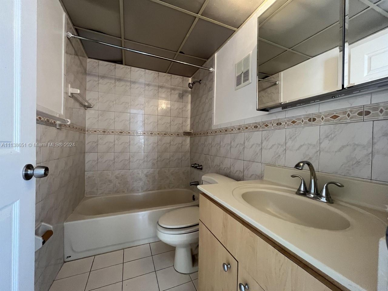 6445 Indian Creek Drive, Unit B16 Miami Beach, FL 33141 - Photo 7 of 18 a bathroom with a sink a toilet and shower