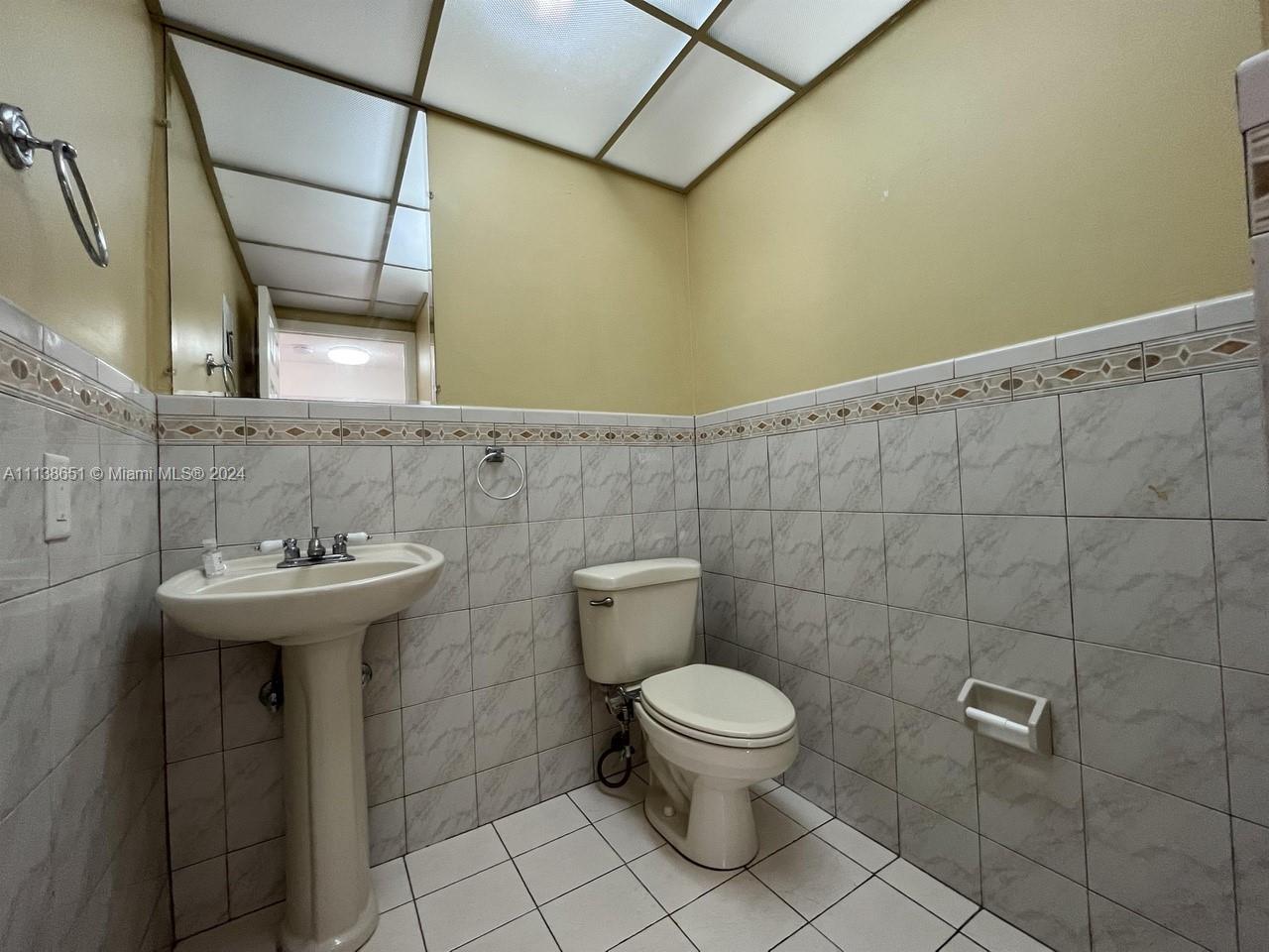 6445 Indian Creek Drive, Unit B16 Miami Beach, FL 33141 - Photo 10 of 18 a bathroom with a sink toilet and a mirror