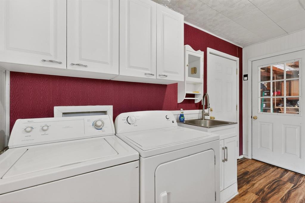 202 Senter Valley Road Irving, TX 75060 - Photo 26 of 32 Dedicated laundry space featuring multiple storage cabinets, a utility sink with a gooseneck faucet, and wood-finish flooring