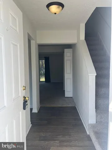 a view of a hallway with wooden floor and closet