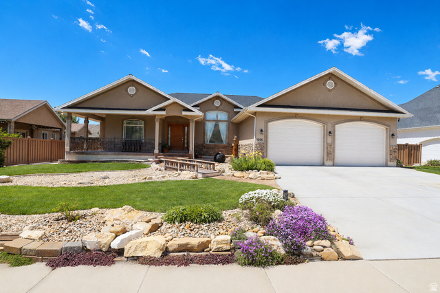 1055 North 1000 East Mapleton, UT 84664 - Photo 105 of 112 Stucco exterior with a covered front porch, dual garage doors, a concrete driveway, and rock landscaping