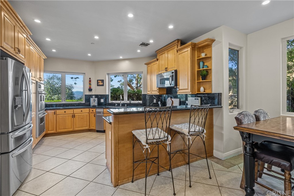 24806 Carlos Place Newhall, CA 91321 - Photo 13 of 44 a kitchen with stainless steel appliances granite countertop a stove a sink and a refrigerator