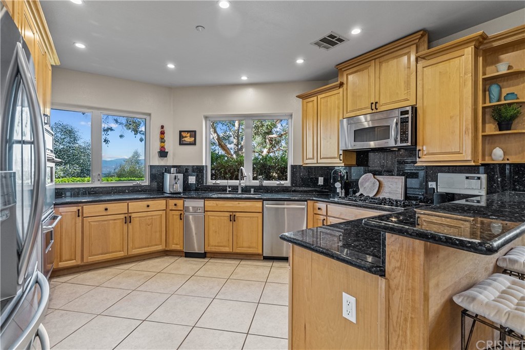 24806 Carlos Place Newhall, CA 91321 - Photo 14 of 44 a kitchen with stainless steel appliances granite countertop a stove sink and cabinets