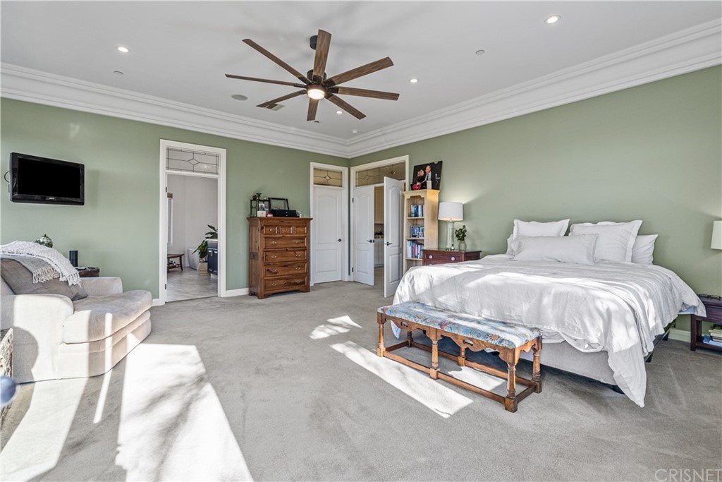 24806 Carlos Place Newhall, CA 91321 - Photo 27 of 44 a spacious bedroom with a bed and a flat screen tv