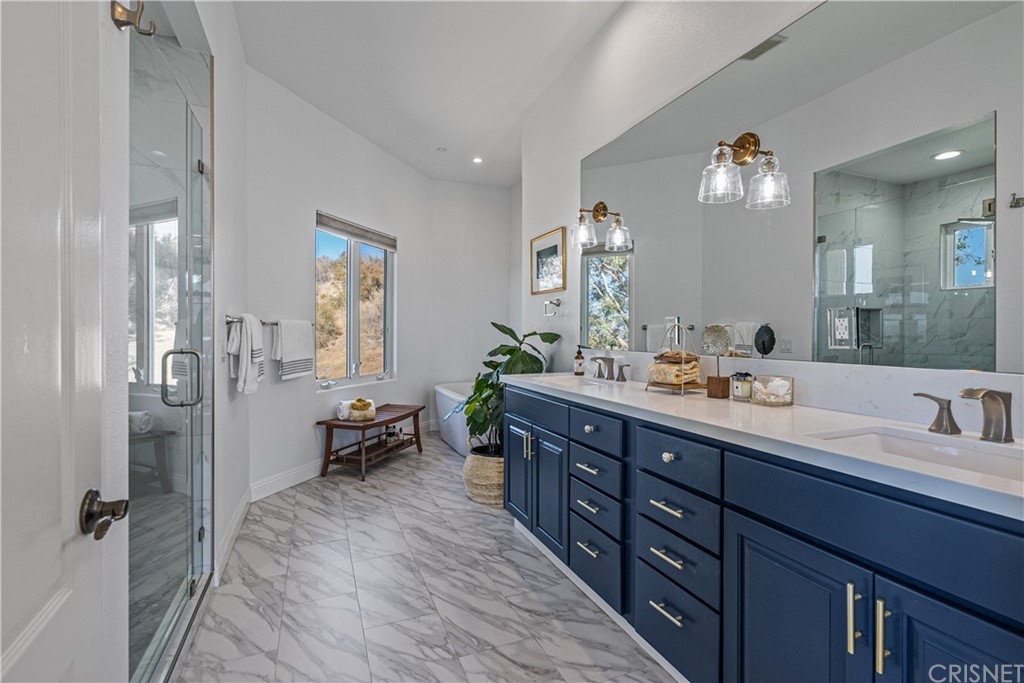 24806 Carlos Place Newhall, CA 91321 - Photo 28 of 44 a spacious bathroom with double vanity sinks a mirror and a shower