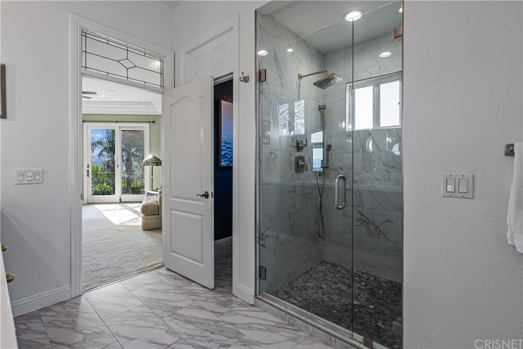 24806 Carlos Place Newhall, CA 91321 - Photo 31 of 44 a bathroom with a glass shower door