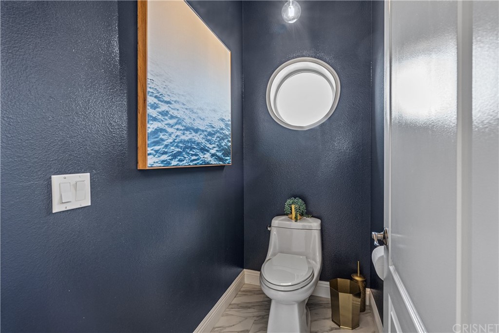 24806 Carlos Place Newhall, CA 91321 - Photo 32 of 44 a white toilet sitting next to a bathroom sink and vanity