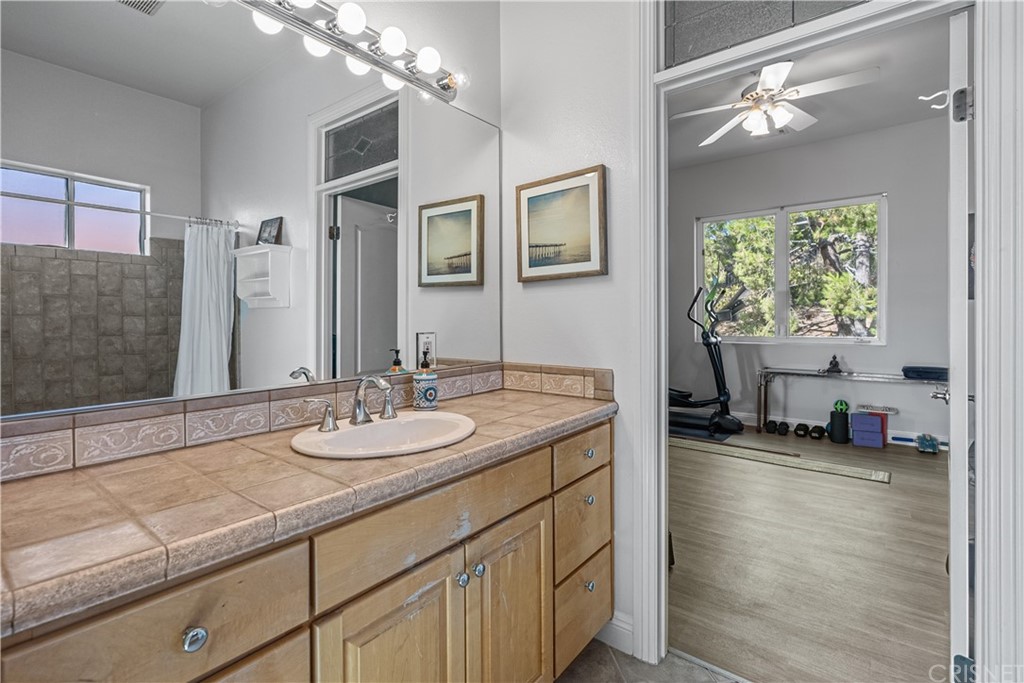 24806 Carlos Place Newhall, CA 91321 - Photo 35 of 44 a bathroom with a granite countertop sink a toilet and a mirror