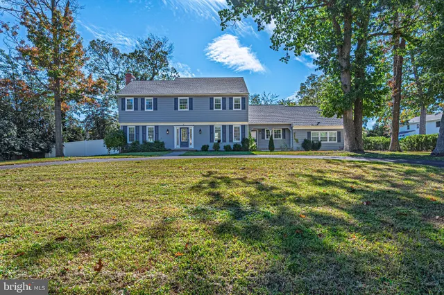 a view of a house with a big yard and palm trees