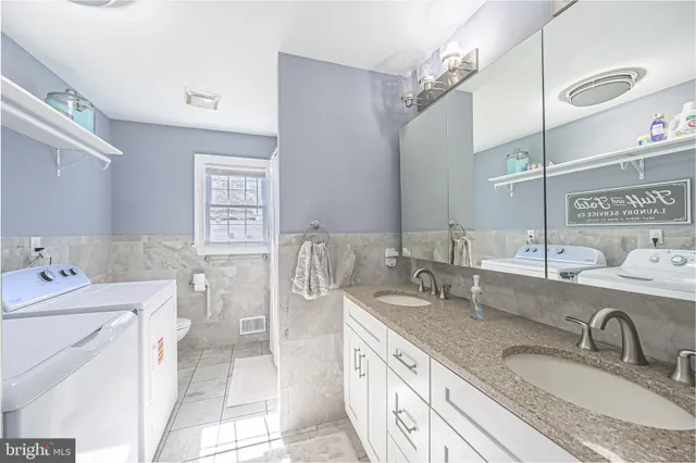 a bathroom with double vanity sinks a mirror and a shower