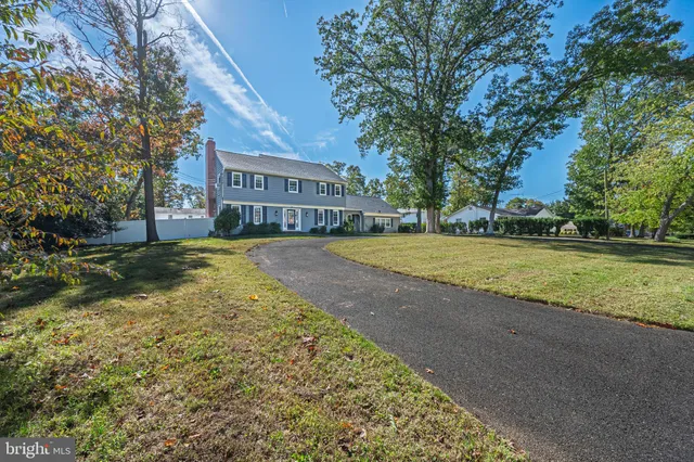 a view of a house with a big yard and large trees