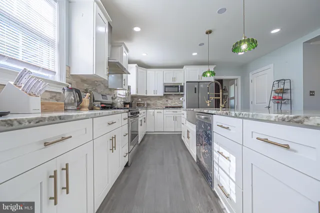 a kitchen with kitchen island granite countertop lots of counter top space and stainless steel appliances