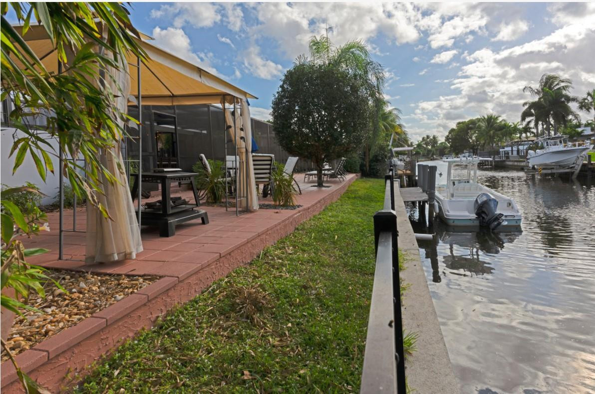 1311 Southwest 56th Avenue Plantation, FL 33317 - Photo 29 of 31 a view of a lake with a house and a garden