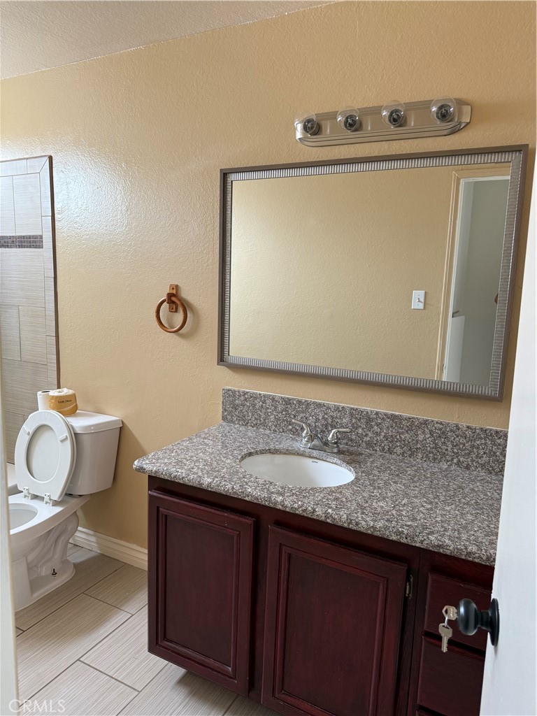 3791-3791 Harvill Lane, Unit 4 Riverside, CA 92503 - Photo 5 of 10 a bathroom with a granite countertop sink and a mirror