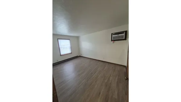 a view of a room with wooden floor