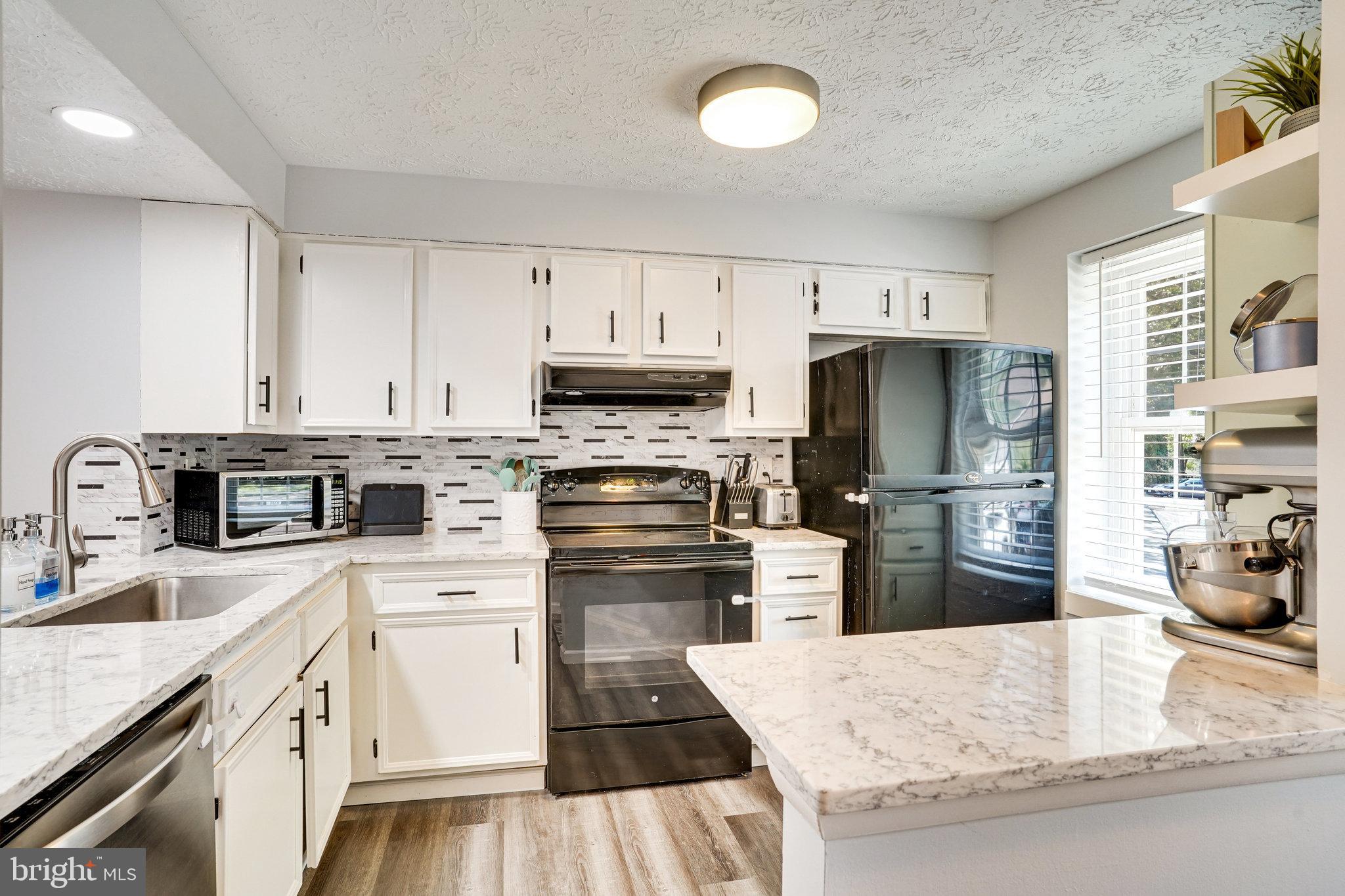 8345 Windfall Road Springfield, VA 22153 - Photo 5 of 30 a kitchen with kitchen island sink refrigerator stove and oven