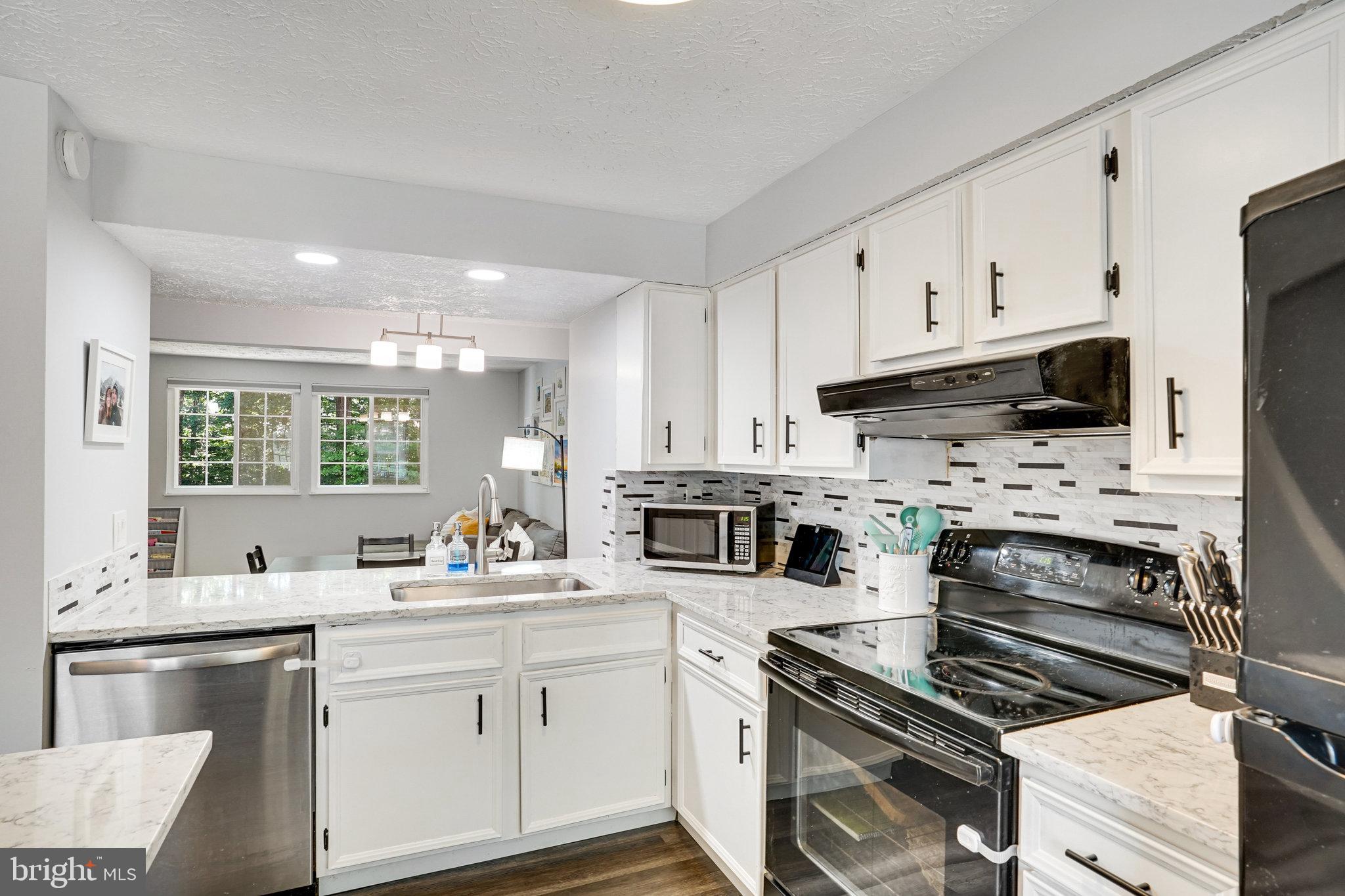 8345 Windfall Road Springfield, VA 22153 - Photo 6 of 30 a kitchen with stainless steel appliances a stove sink microwave and cabinets