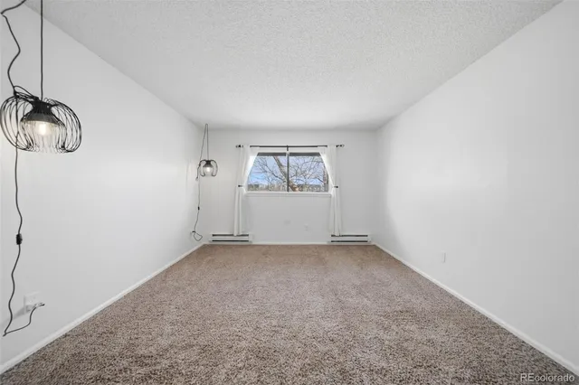 an empty room with windows and cabinet