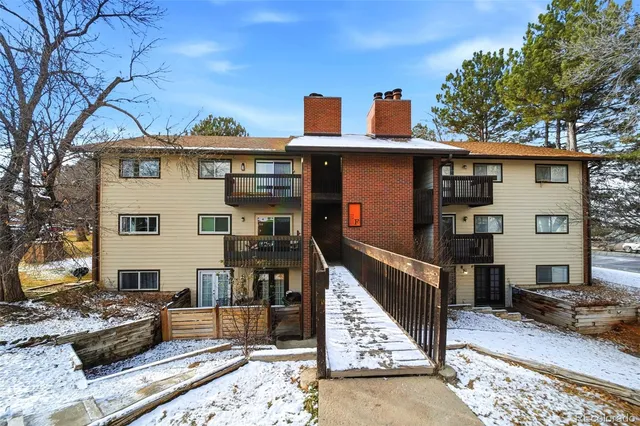 a view of a house with wooden deck and furniture