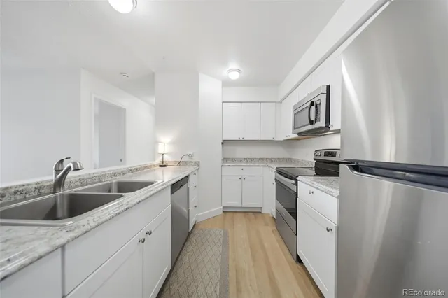 a kitchen with white cabinets sink and white appliances