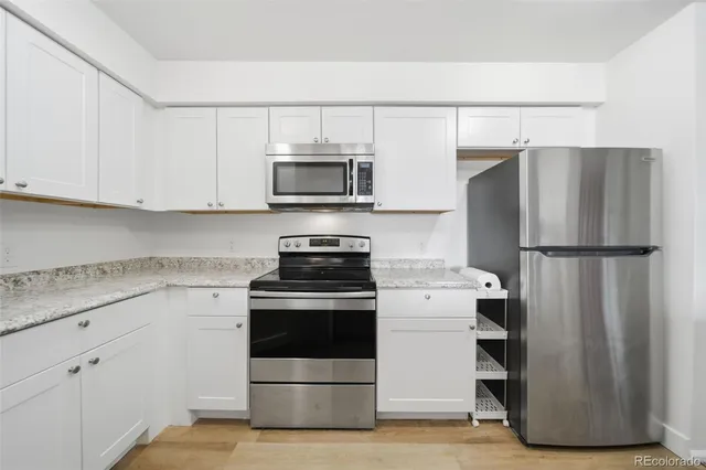 a kitchen with white cabinets and stainless steel appliances