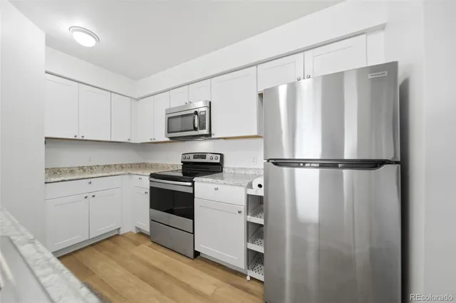 a kitchen with cabinets stainless steel appliances and a refrigerator