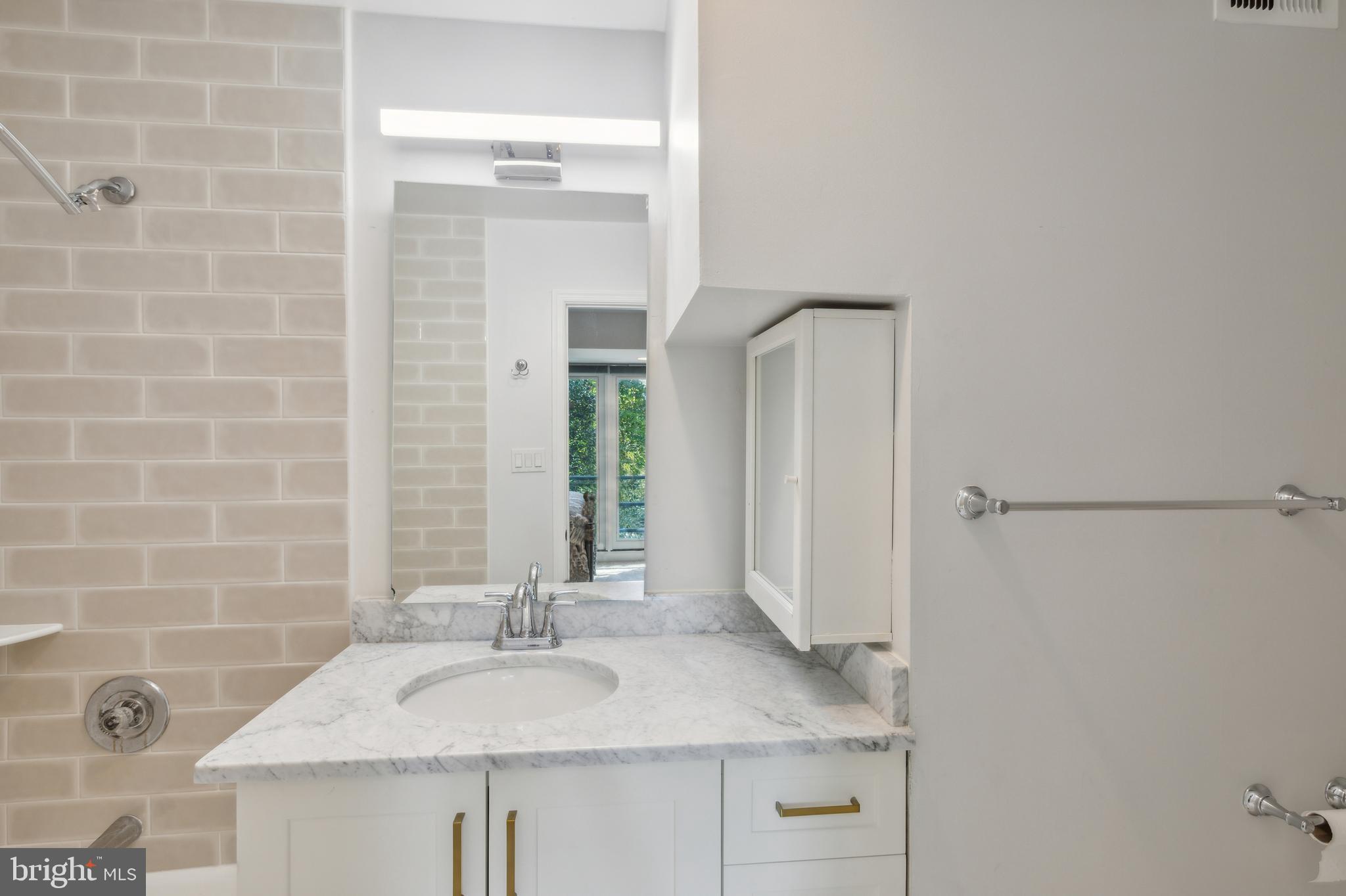 2519 I Street Northwest, Unit 1 Washington, DC 20037 - Photo 31 of 71 a bathroom with a granite countertop sink and a mirror