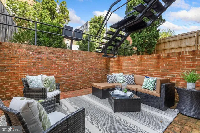 an empty room with wooden floor fireplace and windows