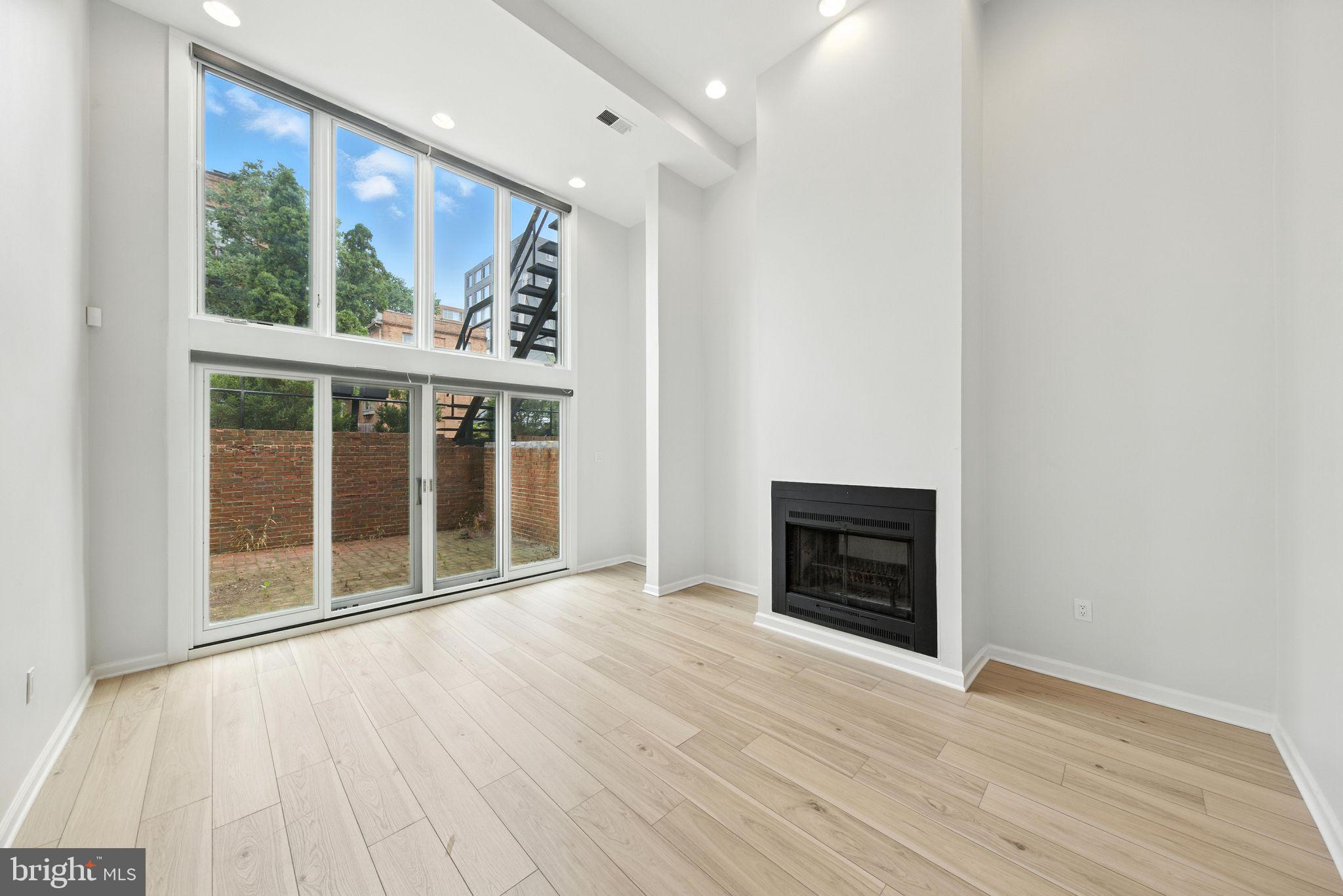 2519 I Street Northwest, Unit 1 Washington, DC 20037 - Photo 56 of 71 an empty room with wooden floor fireplace and windows