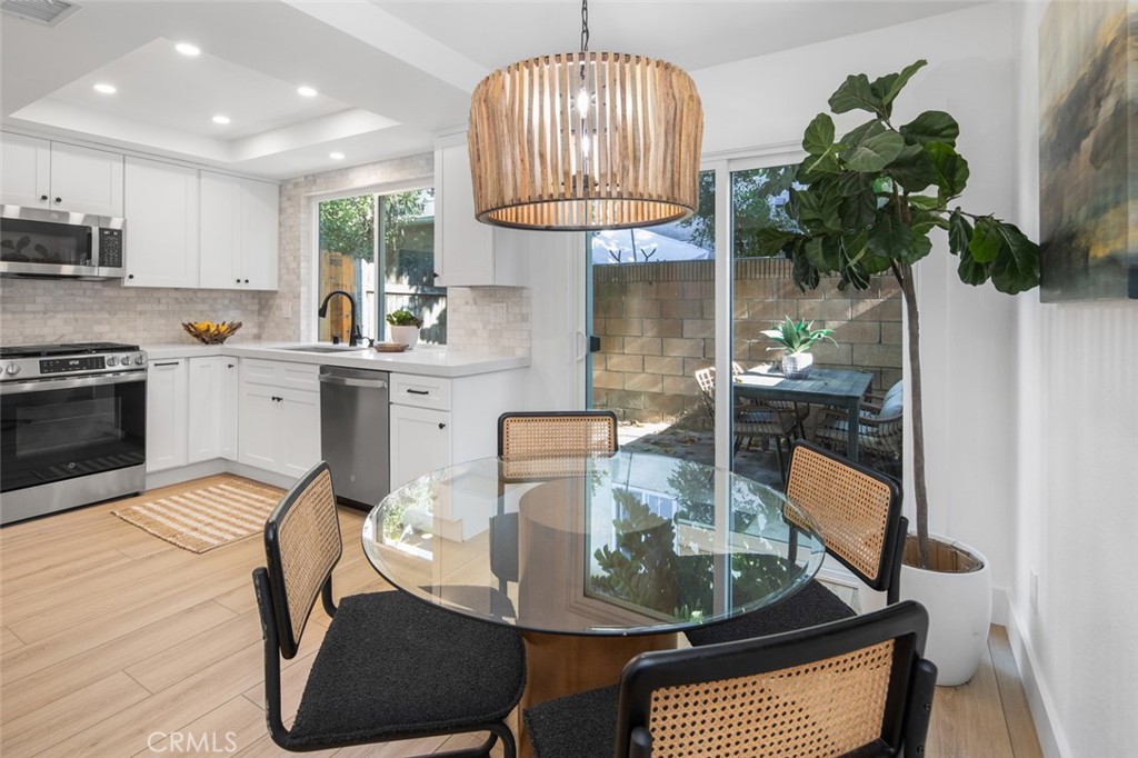 3905 Hazard Avenue, Unit B22 Santa Ana, CA 92703 - Photo 7 of 30 a kitchen with stainless steel appliances granite countertop a stove a sink dishwasher a dining table and chair with wooden floor