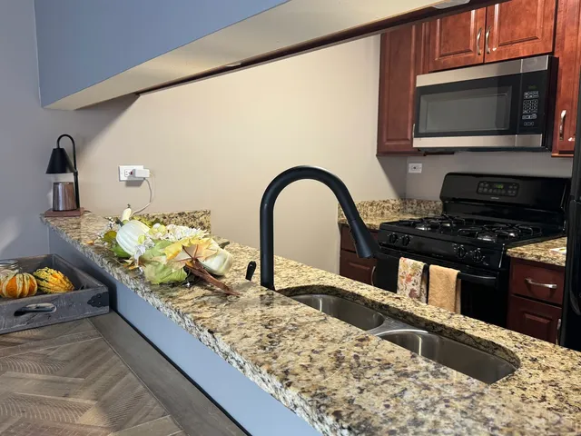 a kitchen with stainless steel appliances kitchen island a stove a sink and a microwave