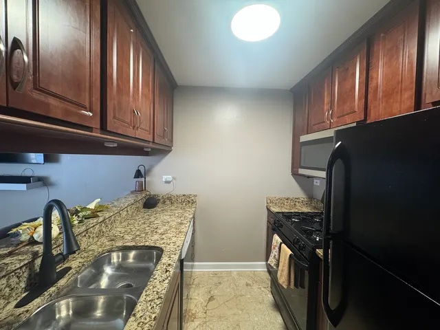 a kitchen with granite countertop stainless steel appliances and wooden cabinets