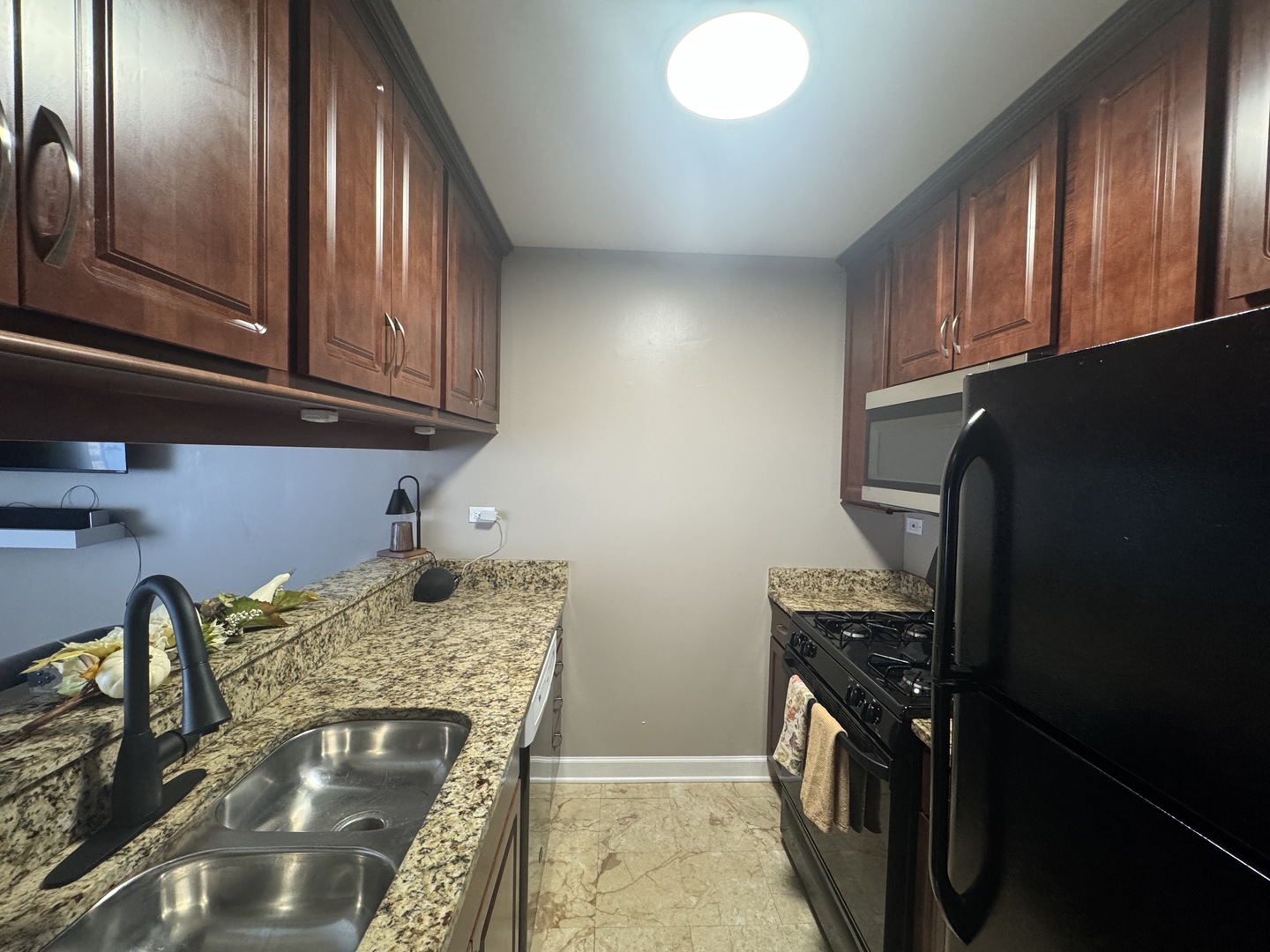 1926 Prairie Square, Unit 302 Schaumburg, IL 60173 - Photo 5 of 16 a kitchen with granite countertop stainless steel appliances and wooden cabinets