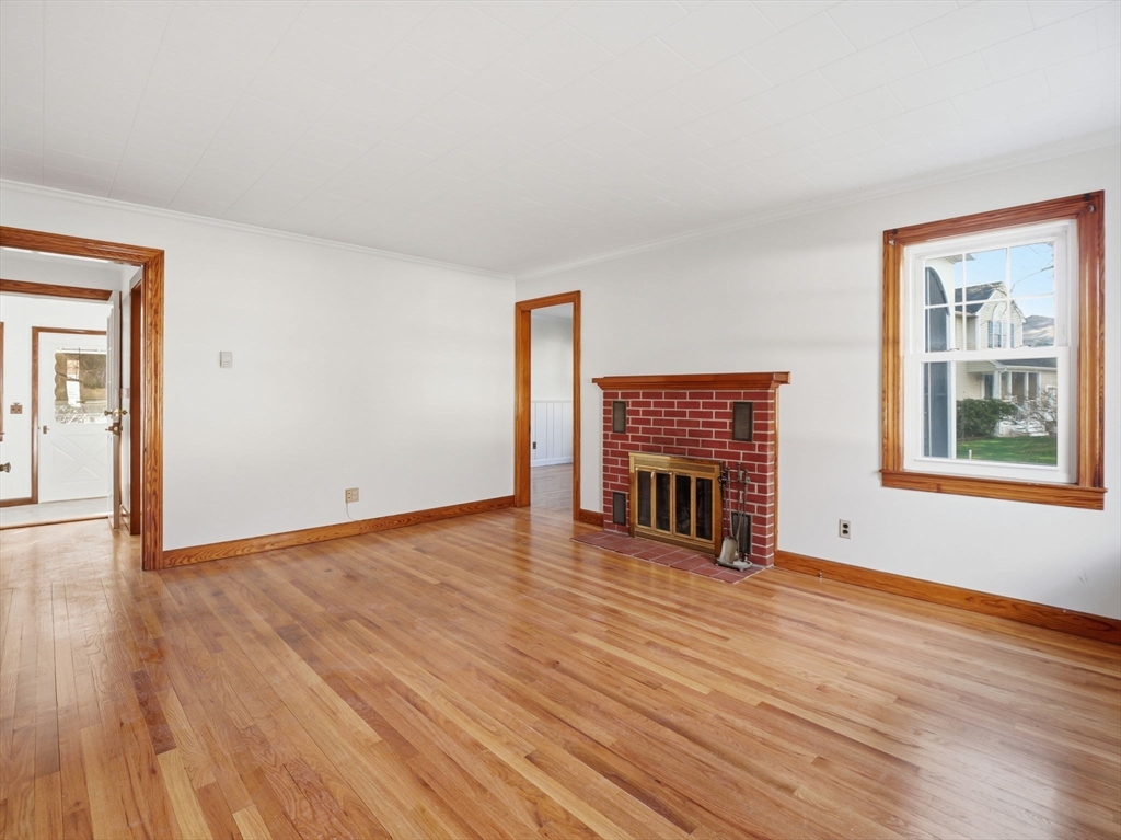 285 West Meadow Road Lowell, MA 01854 - Photo 11 of 32 a view of an empty room with wooden floor fireplace and a window