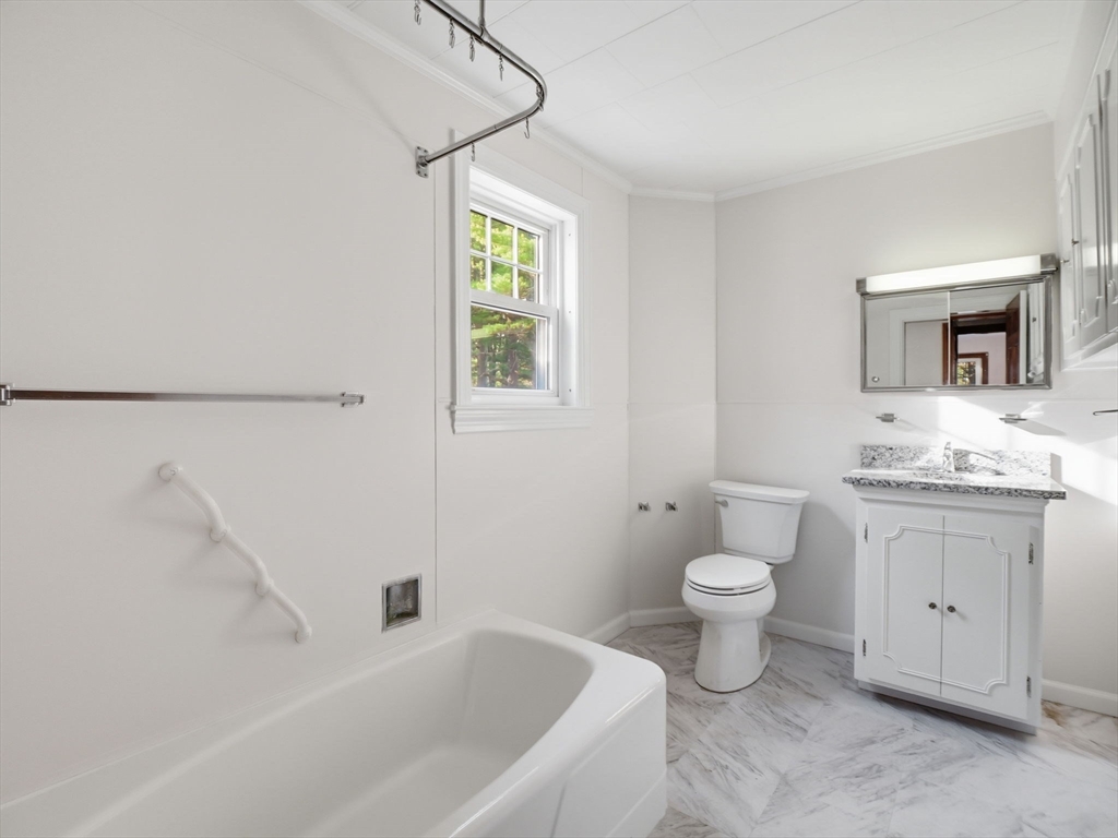 285 West Meadow Road Lowell, MA 01854 - Photo 15 of 32 a bathroom with a toilet sink and mirror